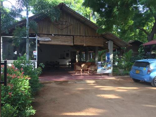 dom z niebieskim samochodem zaparkowanym przed nim w obiekcie So-J Beach Villa w mieście Trikunamalaja