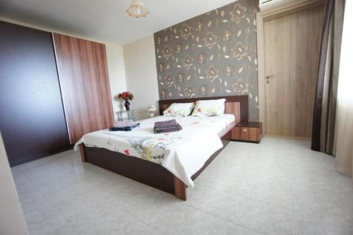 a bedroom with a bed and a wall at Kabakum Holiday Apartment in Varna City