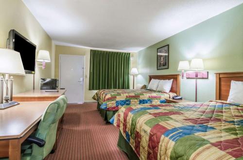 a hotel room with two beds and a desk at Regency Inn in Concordia