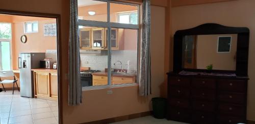 a room with a kitchen with a window and a dresser at Villas JABEL TINAMIT in Panajachel
