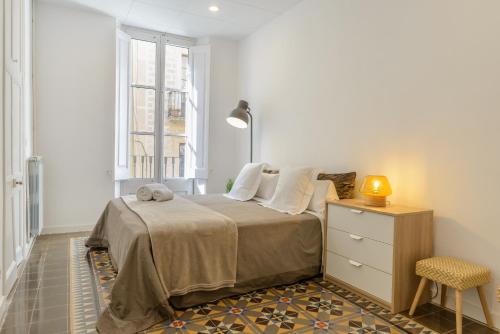1 dormitorio con 1 cama, vestidor y ventana en APG Carrer Nou 10, en Girona