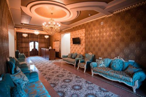 a living room with blue couches and a television at Caravan Castle Boutique Hotel in Bukhara