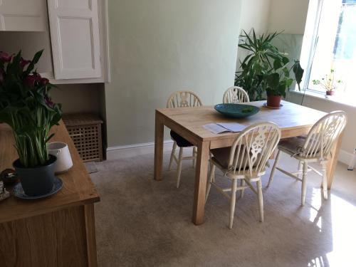 mesa de comedor con sillas y mesa de madera en La casa de Eloisa, en Macclesfield