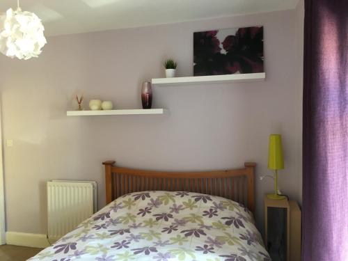 a bedroom with a bed and two shelves on the wall at La casa de Eloisa in Macclesfield