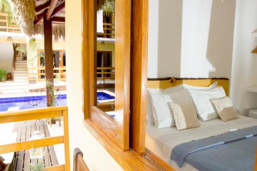 a bedroom with a bed with a mirror at Villa Água de Coco in Jericoacoara