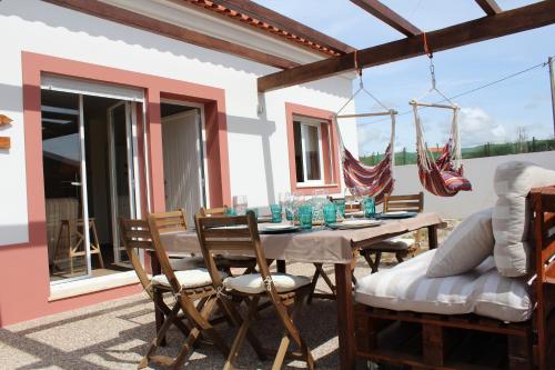 a dining table and chairs on a patio at Number 10 Beach House in A dos Cunhados