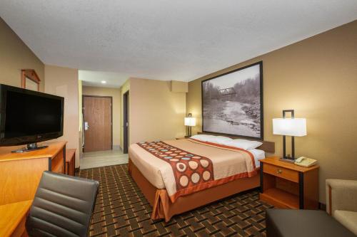 a hotel room with a bed and a flat screen tv at Super 8 by Wyndham Ottawa in Ottawa