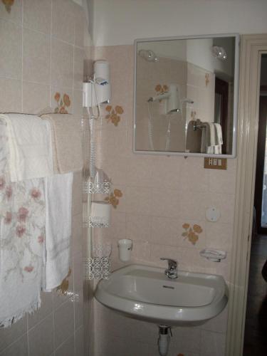 a bathroom with a sink and a mirror and towels at B&B Astor in Alleghe