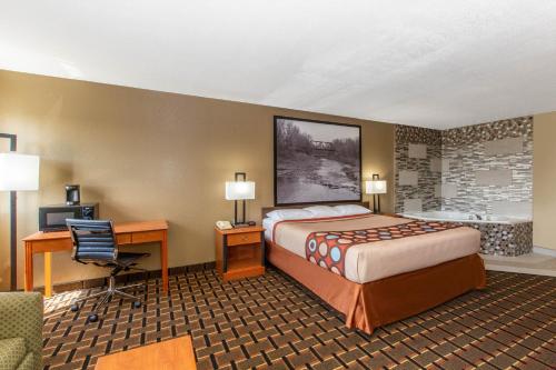 ein Hotelzimmer mit einem Bett, einem Schreibtisch und einem Computer in der Unterkunft Super 8 by Wyndham Ottawa in Ottawa