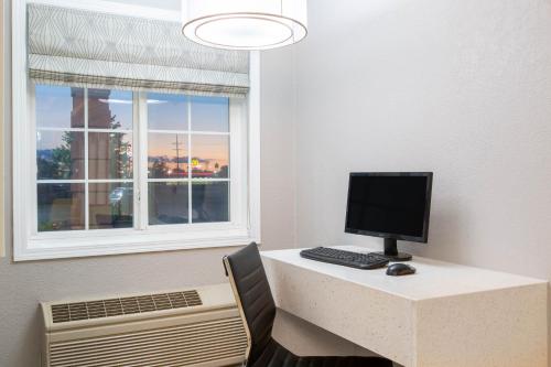 a desk with a computer on it next to a window at Super 8 by Wyndham Ottawa in Ottawa