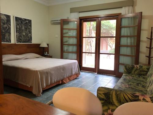 1 dormitorio con cama, sofá y mesa en Suite 1108 em Flat frente ao mar en Ilhabela
