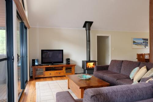 a living room with a couch and a tv at Treehouse-elevated nature setting, kids TV room in Quindalup