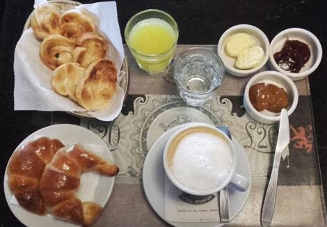 a table topped with plates of pastries and a cup of coffee at Hosteria Maryland in Posadas