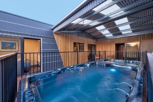 a hot tub on the balcony of a house at Containment Accommodation in Coles Bay