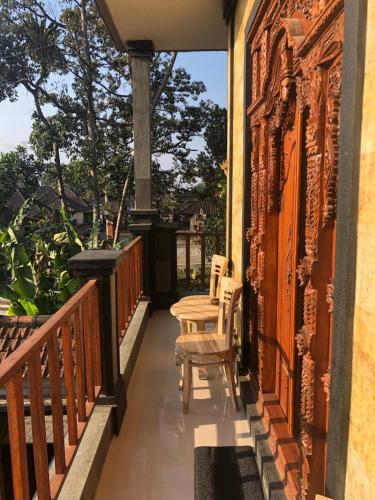 a porch with two chairs and a table on it at SARI SEDANA HOME STAY in Gianyar
