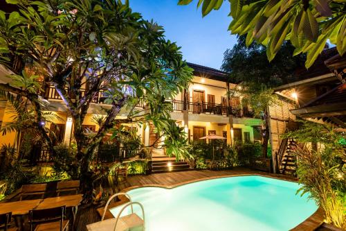 an indoor pool in front of a building with trees at Amata Lanna Chiang Mai, One Member of the Secret Retreats in Chiang Mai