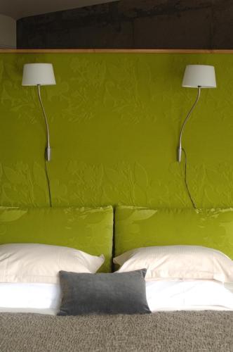 a bedroom with a green headboard with two lamps at Villa Lodge 4 Epices in Gustavia