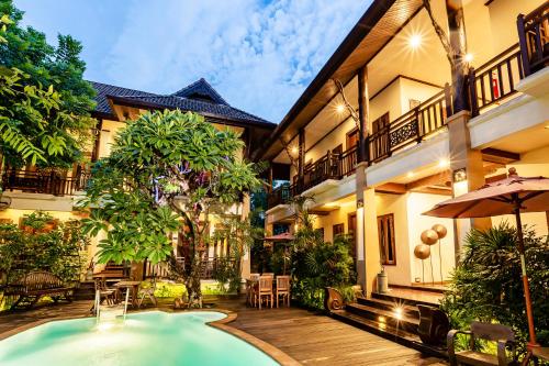 a hotel with a swimming pool in front of a building at Amata Lanna Chiang Mai, One Member of the Secret Retreats in Chiang Mai