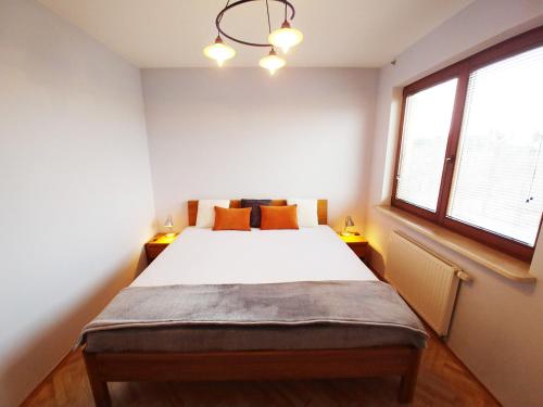 a bedroom with a large white bed with two windows at Apartament, Kwatera Prywatna MARINA z garażem tarasem i wifi, blisko plaży, na przeciwko Parku Reagana in Gdańsk