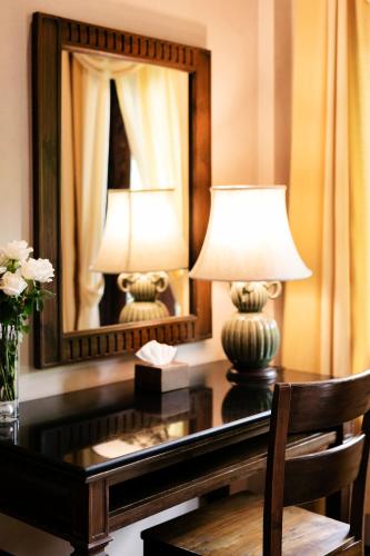 a desk with a lamp and a mirror at Amata Lanna Chiang Mai, One Member of the Secret Retreats in Chiang Mai