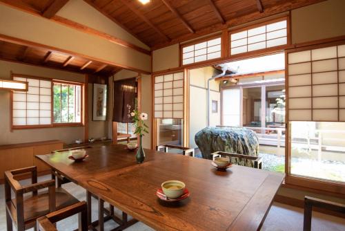 - une salle à manger avec une table et des chaises en bois dans l'établissement Nachiya, à Kyoto