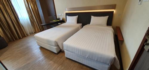a hotel room with two beds in a room at The Capital Residence Suites in Bandar Seri Begawan