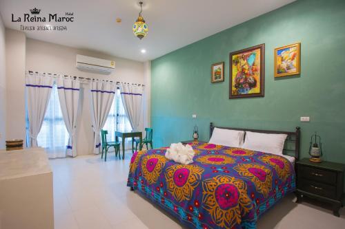 a bedroom with a bed with a colorful bedspread at La Reina Maroc Hotel ปากช่อง เขาใหญ่ in Pak Chong