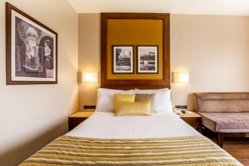 a hotel room with a bed and a chair at Sun-n-Sand Shirdi in Shirdi