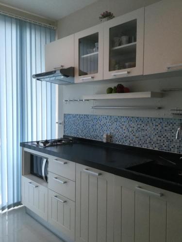 a kitchen with white cabinets and a black counter top at Best Point Condominium Cape Panwa in Phuket