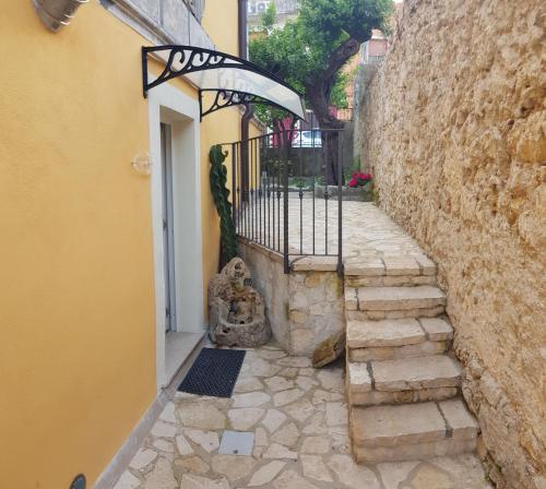 un callejón de piedra con una puerta y una pared de piedra en Il Daviduccio Suite, en Siracusa