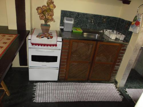 una pequeña cocina con fogones y fregadero en Chalé Barra Velha, en Ilhabela