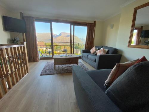 a living room with a couch and a table at Highland Self Catering Retreat With Stunning Views in Fort William