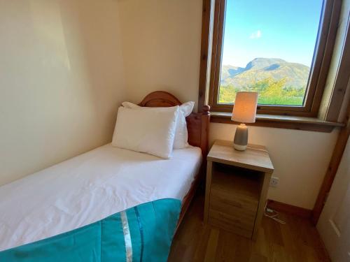 フォート・ウィリアムにあるHighland Self Catering Retreat With Stunning Viewsの小さなベッドルーム(ベッド1台、窓付)