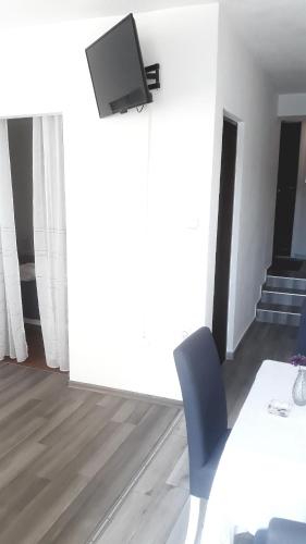 a room with a table and a tv on a wall at Apartmani Leženić Dada in Neum