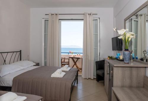 アギア・ペラギア・キュティーラにあるAnesis Hotelのベッド付きのホテルルームで、海の景色を望めます。