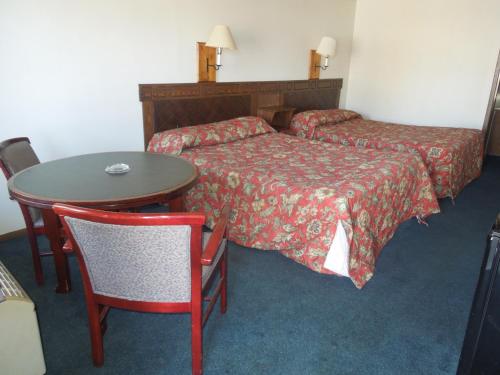a hotel room with two beds and a table and chair at Xenia Country Inn in Xenia