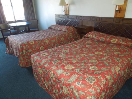 a hotel room with two beds and a table at Xenia Country Inn in Xenia