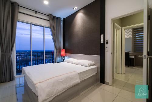 a bedroom with a bed and a large window at JOMSTAY Majestic Premier Suites Ipoh Town in Ipoh