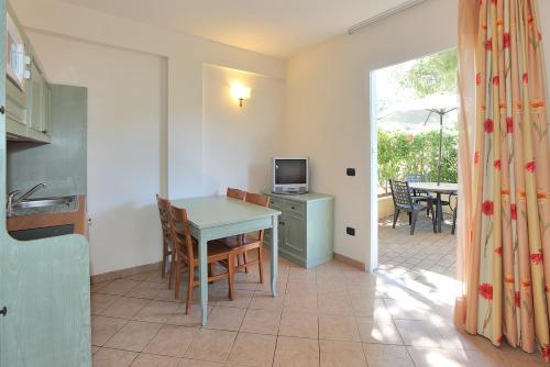 a kitchen and dining room with a table and a television at Il Villaggio Di Giuele in Finale Ligure