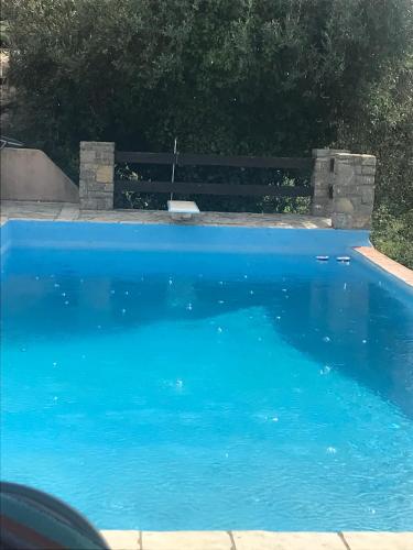 a blue swimming pool with a bench next to it at ZenTerra Country house with prive swimming pool and view in Matésion