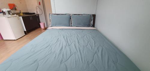 a bed in a room with a blue blanket at Gangchon Beautiful Pension in Chuncheon