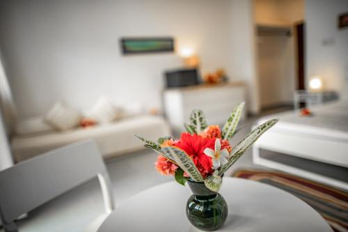 a vase with flowers on a table in a living room at Kibanda Lodge and Beach Club in Nungwi