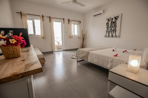 a bedroom with a bed and a table with a candle at Kibanda Lodge and Beach Club in Nungwi
