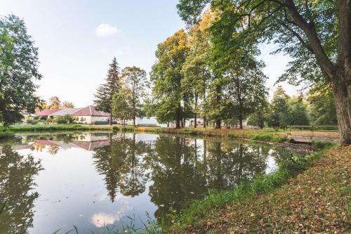 vistas a un estanque en un parque con árboles en Pivovar a Penzion GRASEL en Český Rudolec