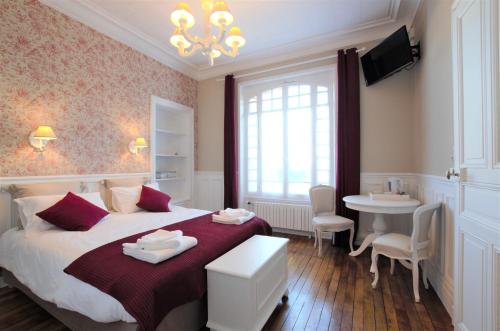 1 dormitorio con cama, mesa y lavamanos en A L'Aube de Troyes, en Sainte-Savine