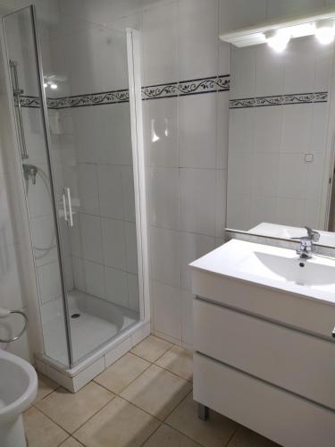 Un baño con ducha, lavabo e inodoro. en Apartamento primera línea de mar, en Hospitalet de l'Infant