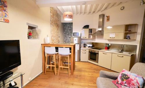 Cette chambre comprend une petite cuisine avec un comptoir et des chaises. dans l'établissement pause café avec sauna, à Annecy