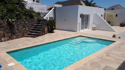a swimming pool in front of a house at Villa Essence - a unique detached villa with heated private pool, hottub, gardens, patios and stunning views! in Tías