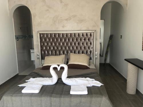 two swans made to look like hearts sitting on a bed at VILLA ALOHA DJERBA plain pied haut de gamme piscine proche de la plage in Midoun