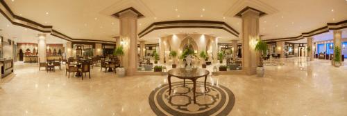 a lobby with a restaurant with tables and chairs at Sunrise Garden Beach Resort in Hurghada